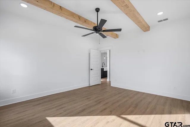 a view of a hallway with wooden floor and a ceiling fan