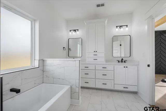 a bathroom with a tub a toilet and a sink