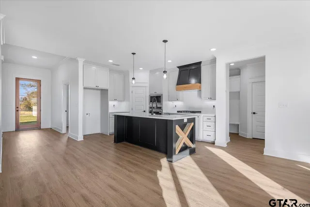 a room with kitchen island a wooden floor and white appliances