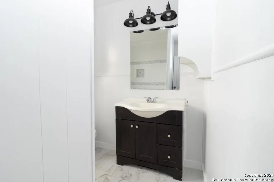 719 Kelly Street Poteet, TX 78065 - Photo 11 of 12 a bathroom with a sink and a mirror