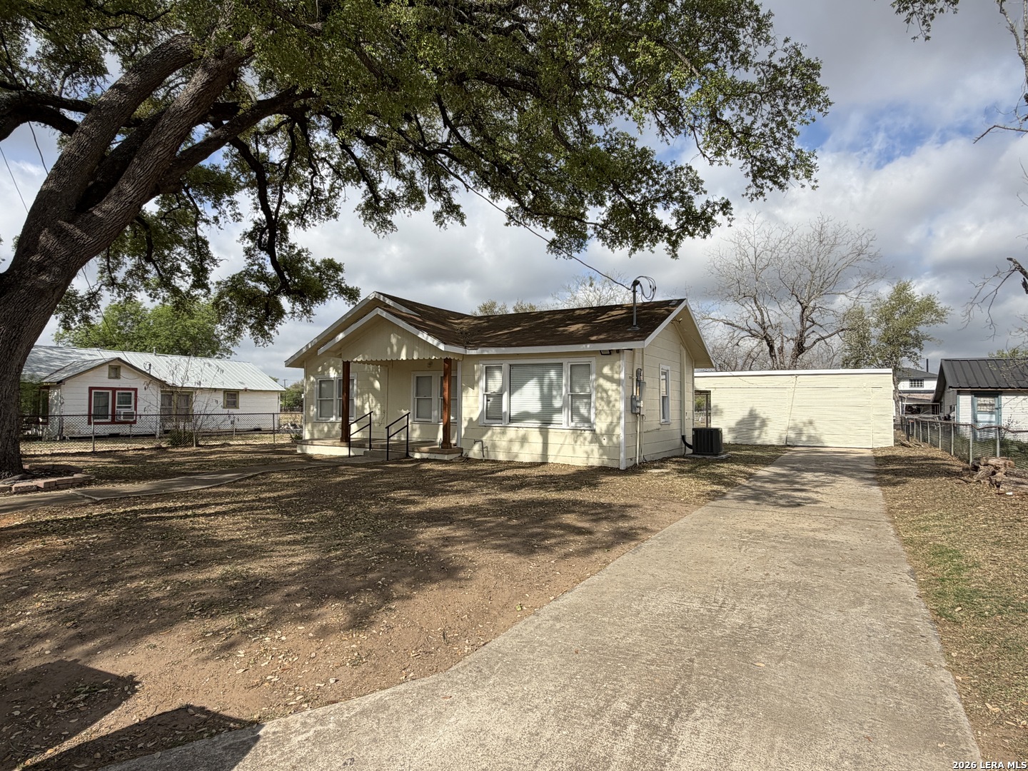 719 Kelly Street Poteet, TX 78065 - Photo 2 of 12 a view of a house with a yard and large trees