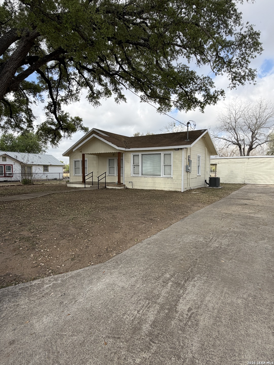 719 Kelly Street Poteet, TX 78065 - Photo 3 of 12 a front view of a house with a garden and trees