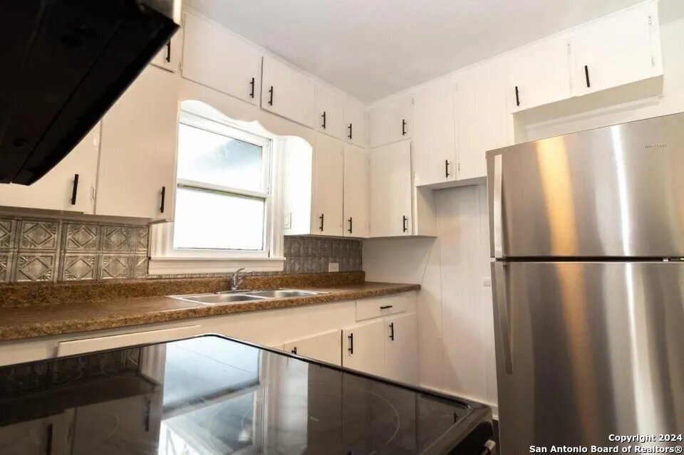 719 Kelly Street Poteet, TX 78065 - Photo 6 of 12 a white refrigerator freezer sitting inside of a kitchen