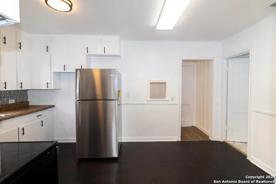 719 Kelly Street Poteet, TX 78065 - Photo 9 of 12 a kitchen with a refrigerator and a stove top oven
