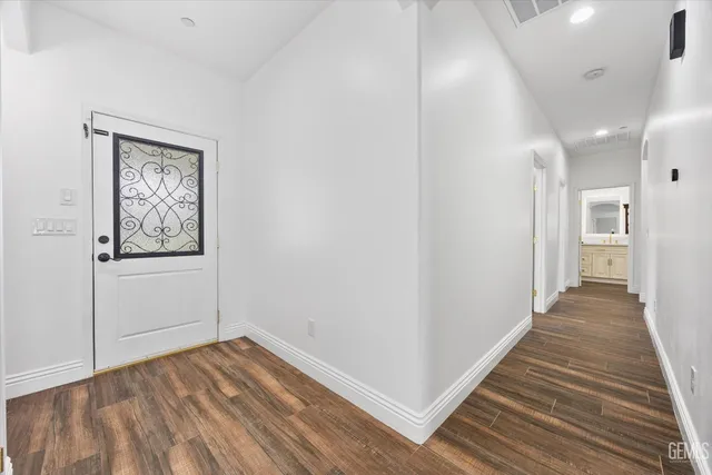 a view of a livingroom with wooden floor and a fireplace