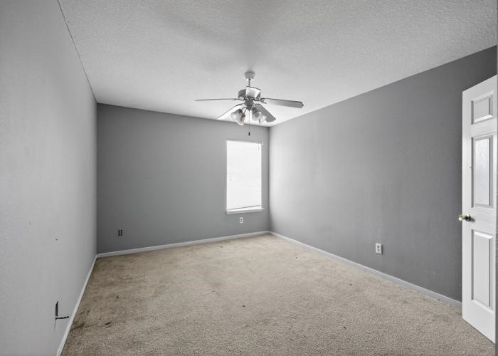 4922 Redwing Brook Trail Katy, TX 77449 - Photo 12 of 22 an empty room with windows and chandelier fan