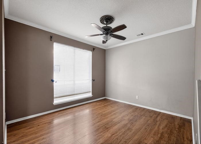 4922 Redwing Brook Trail Katy, TX 77449 - Photo 14 of 22 an empty room with wooden floor fan and windows