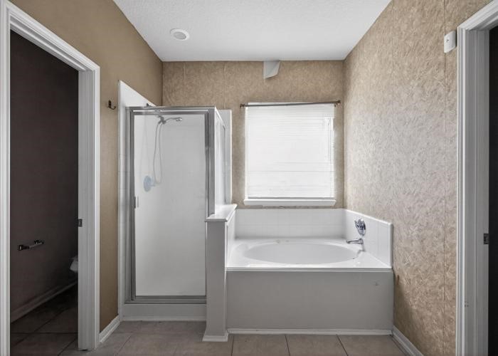 4922 Redwing Brook Trail Katy, TX 77449 - Photo 18 of 22 a bathroom with a bathtub and a shower