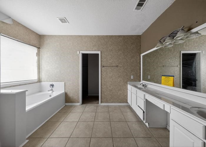 4922 Redwing Brook Trail Katy, TX 77449 - Photo 19 of 22 a bathroom with a bathtub sink and mirror