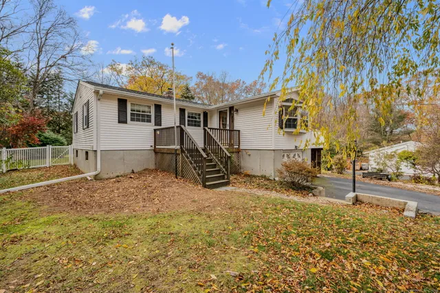 a view of a house with backyard and a tree
