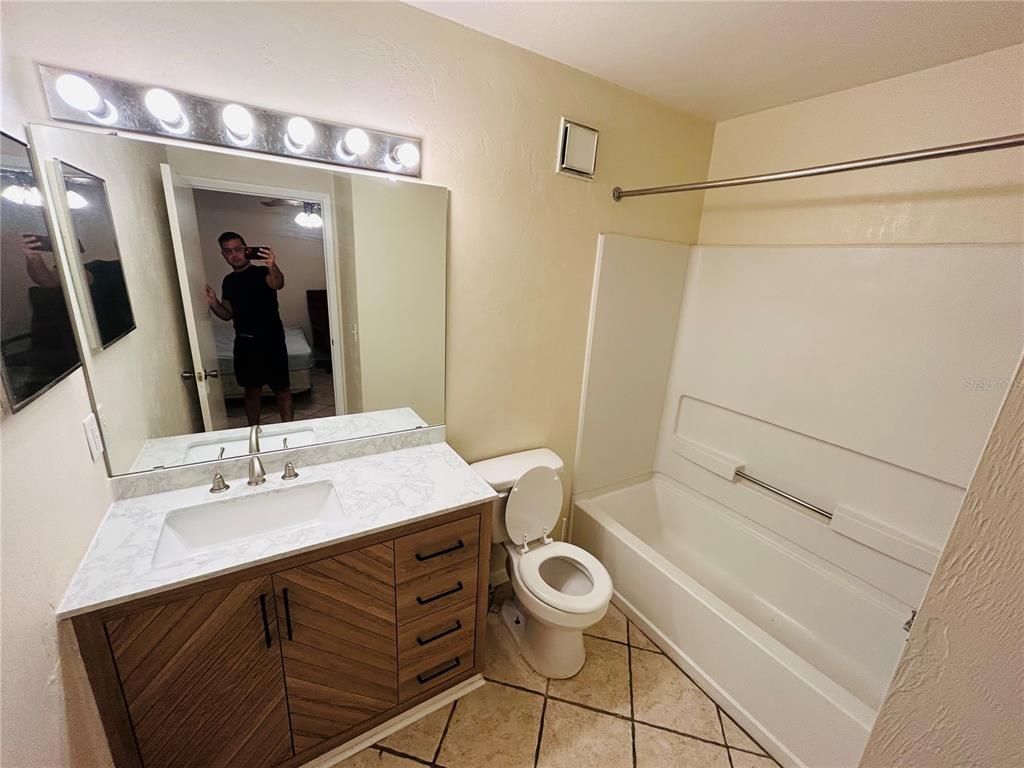 3800 Southwest 20th Avenue, Unit 403 Gainesville, FL 32607 - Photo 6 of 8 a bathroom with a sink a mirror and a bathtub