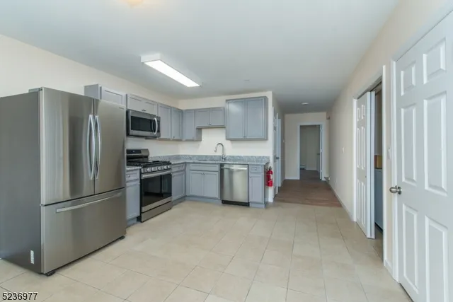 a kitchen with stainless steel appliances a refrigerator and a stove top oven