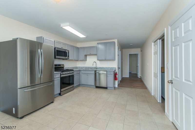 55 Gingerbread Castle Road, Unit 2 Hamburg, NJ 07419 - Photo 2 of 10 a kitchen with stainless steel appliances a refrigerator and a stove top oven