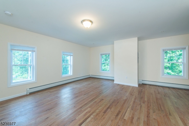 55 Gingerbread Castle Road, Unit 2 Hamburg, NJ 07419 - Photo 4 of 10 an empty room with wooden floor and windows