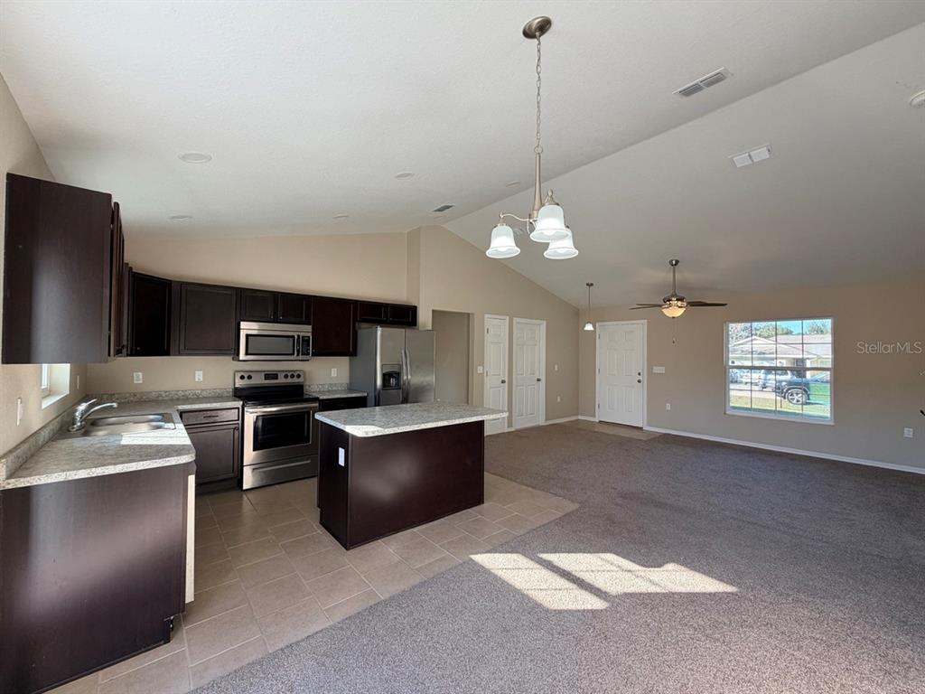 14656 Southwest 21st Place Ocala, FL 34481 - Photo 13 of 52 a kitchen with stainless steel appliances granite countertop a sink refrigerator and microwave