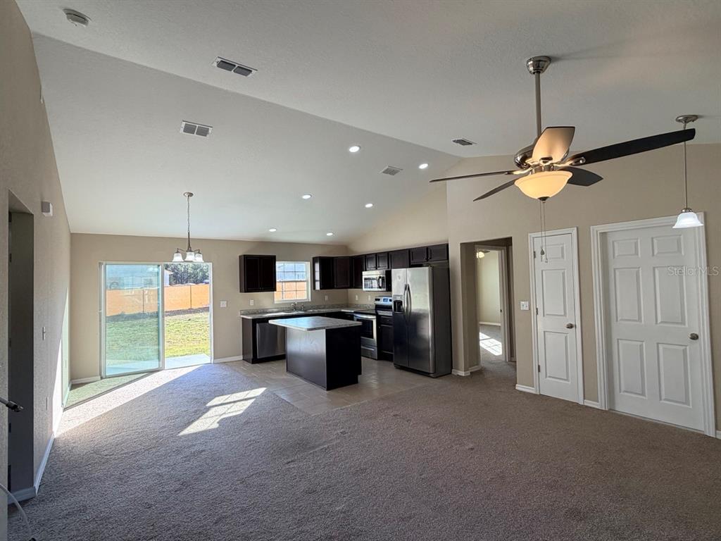14656 Southwest 21st Place Ocala, FL 34481 - Photo 16 of 52 a kitchen with kitchen island a stove a sink a refrigerator and a refrigerator