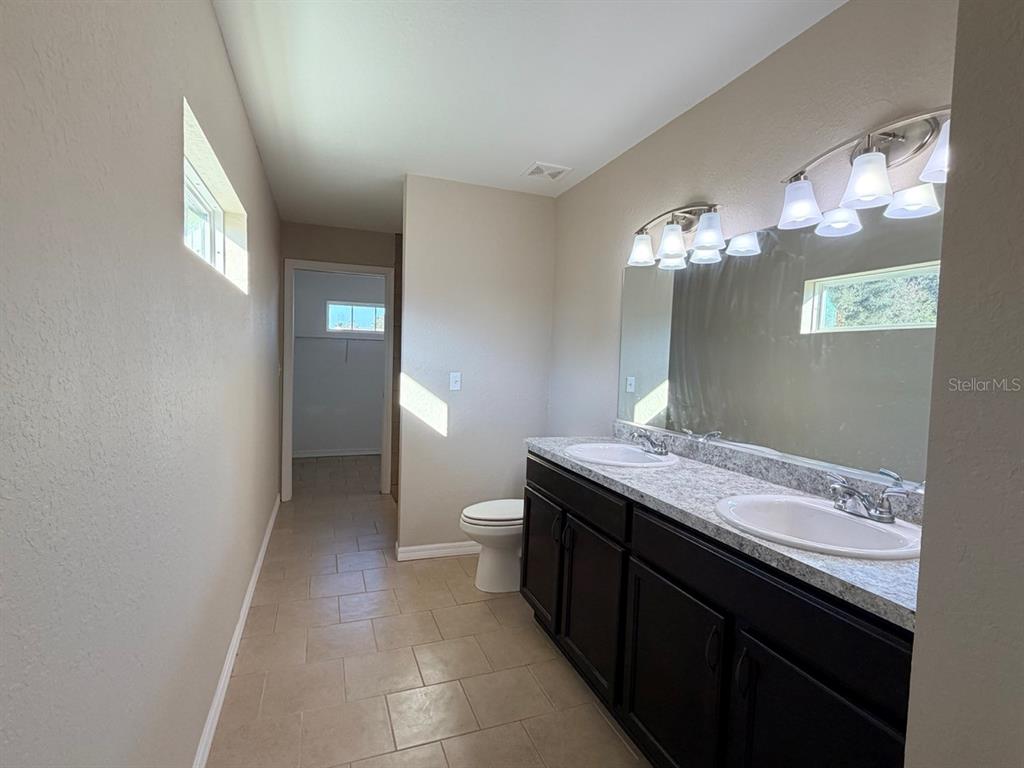 14656 Southwest 21st Place Ocala, FL 34481 - Photo 22 of 52 a spacious bathroom with a granite countertop sink a toilet and a mirror