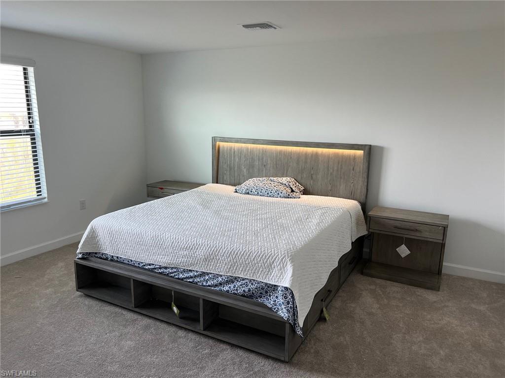 18227 Ridgeline Drive Estero, FL 33928 - Photo 8 of 30 a bed sitting in a bedroom next to a window