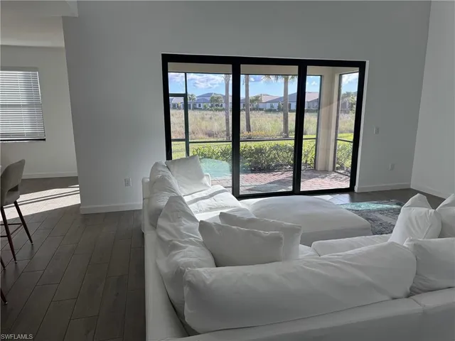 a living room with furniture and a floor to ceiling window