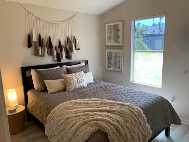 a large bed sitting in a bedroom next to a window