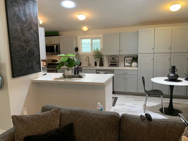a living room with furniture a dining table and kitchen view