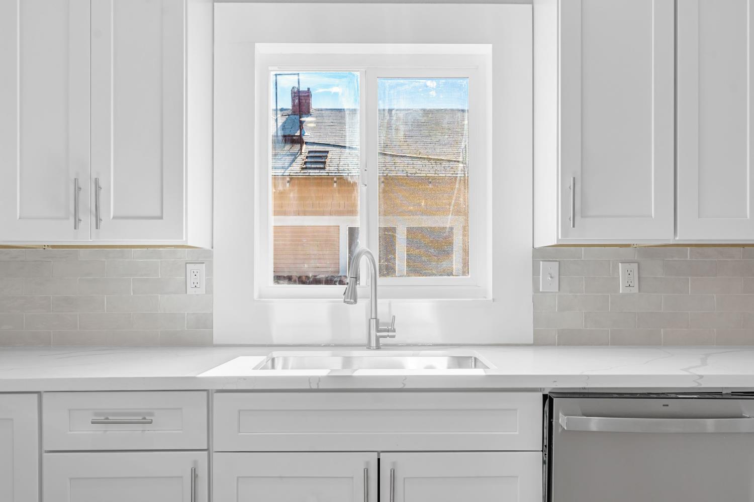 1249 D Street Reedley, CA 93654 - Photo 13 of 40 a kitchen with granite countertop white cabinets and a window