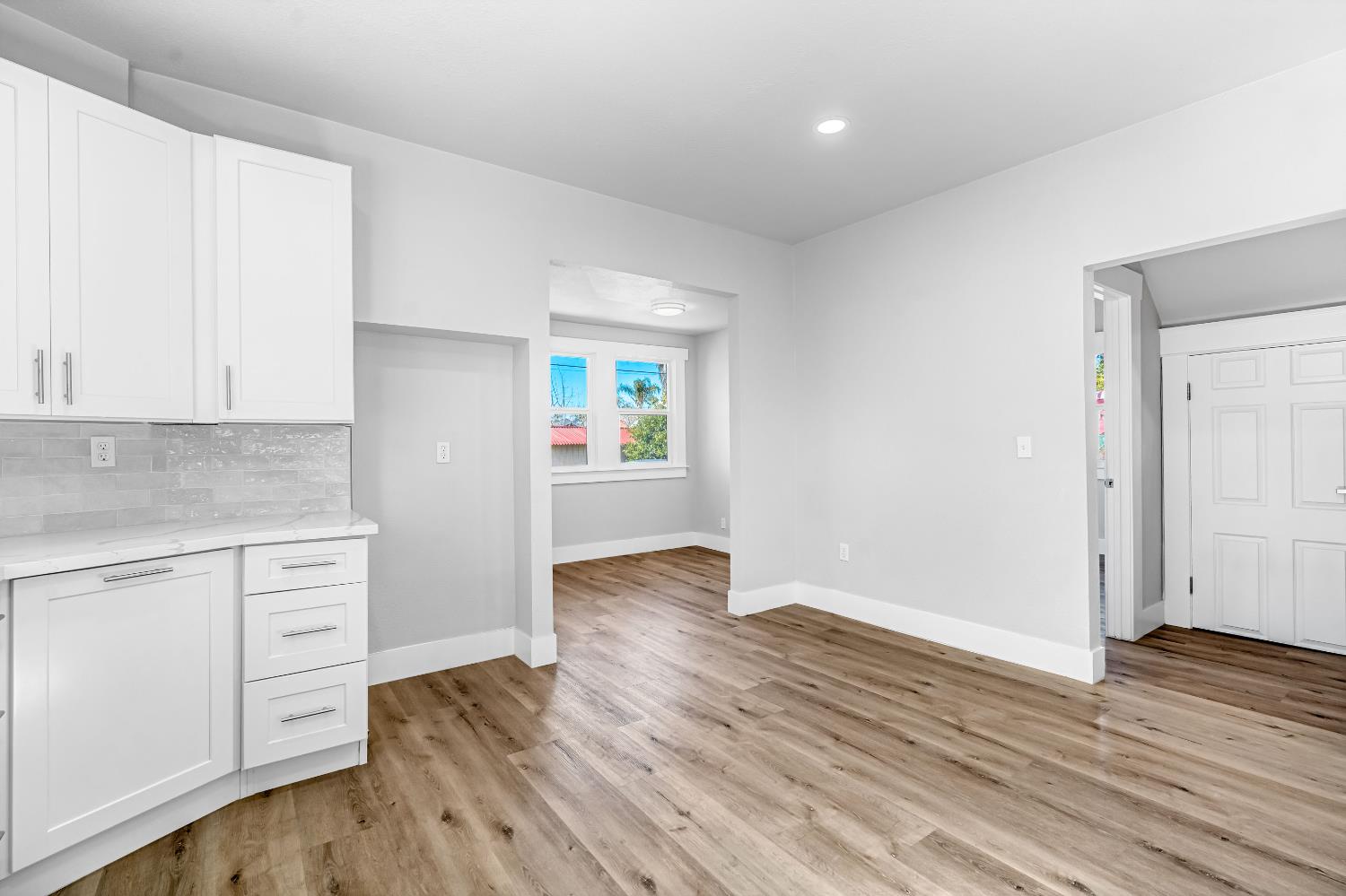 1249 D Street Reedley, CA 93654 - Photo 14 of 40 an empty room with wooden floor cabinet and windows