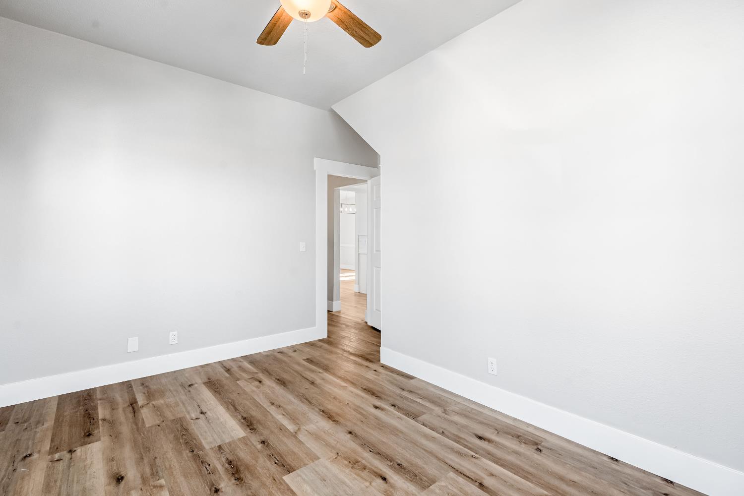 1249 D Street Reedley, CA 93654 - Photo 19 of 40 an empty room with wooden floor and windows