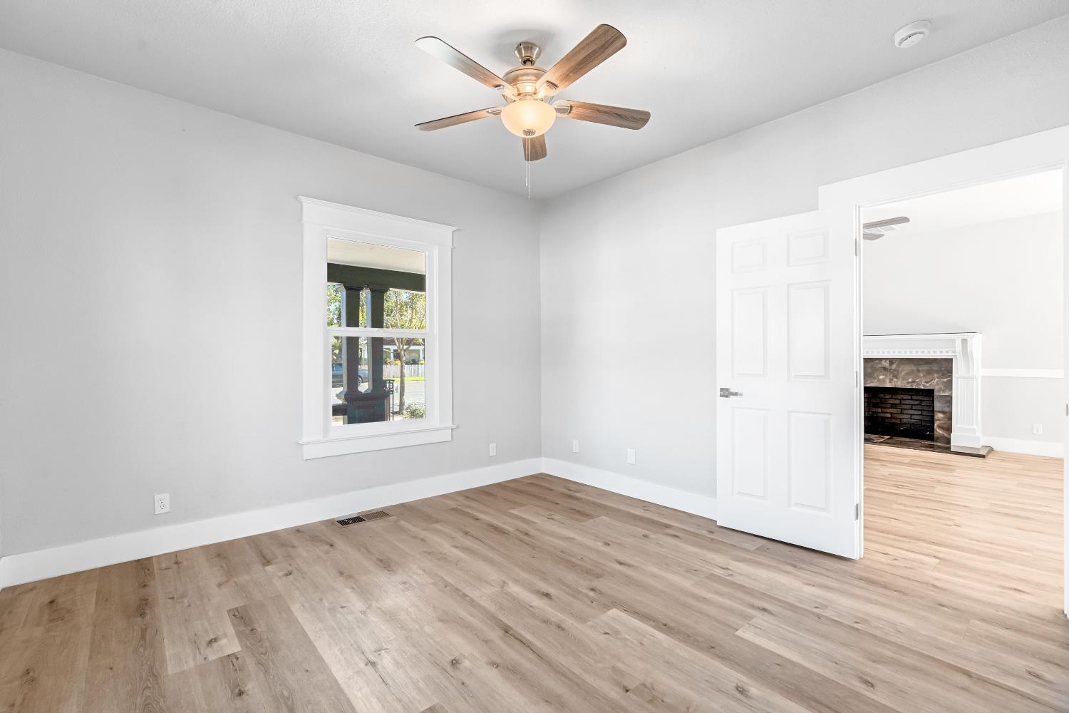 1249 D Street Reedley, CA 93654 - Photo 22 of 40 a view of an empty room with wooden floor and a window