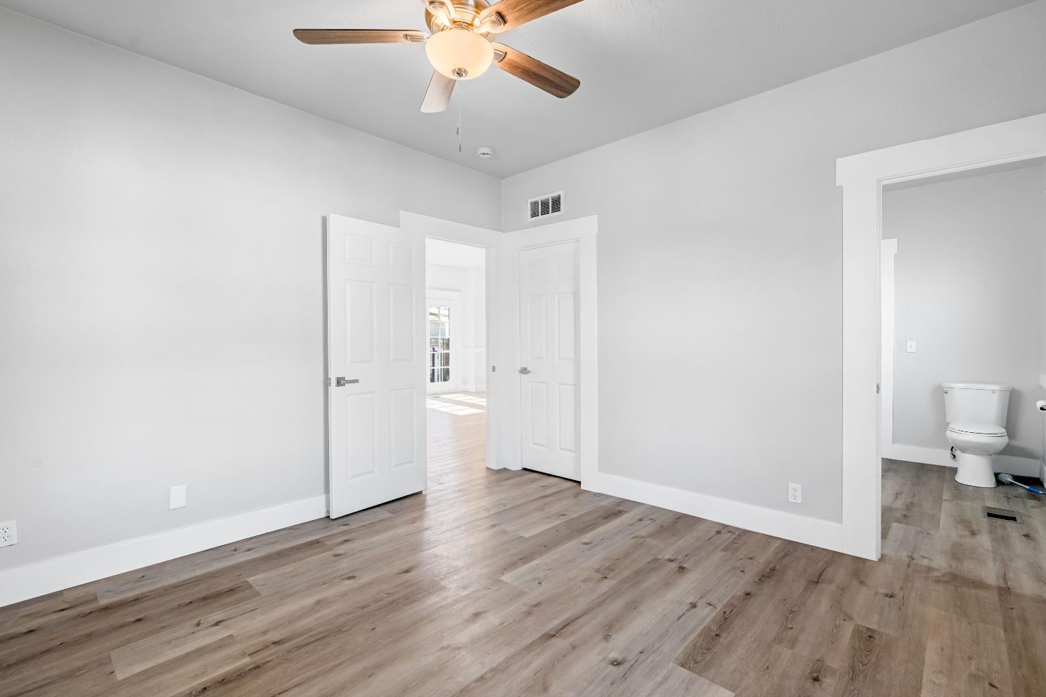 1249 D Street Reedley, CA 93654 - Photo 23 of 40 an empty room with wooden floor and ceiling fan