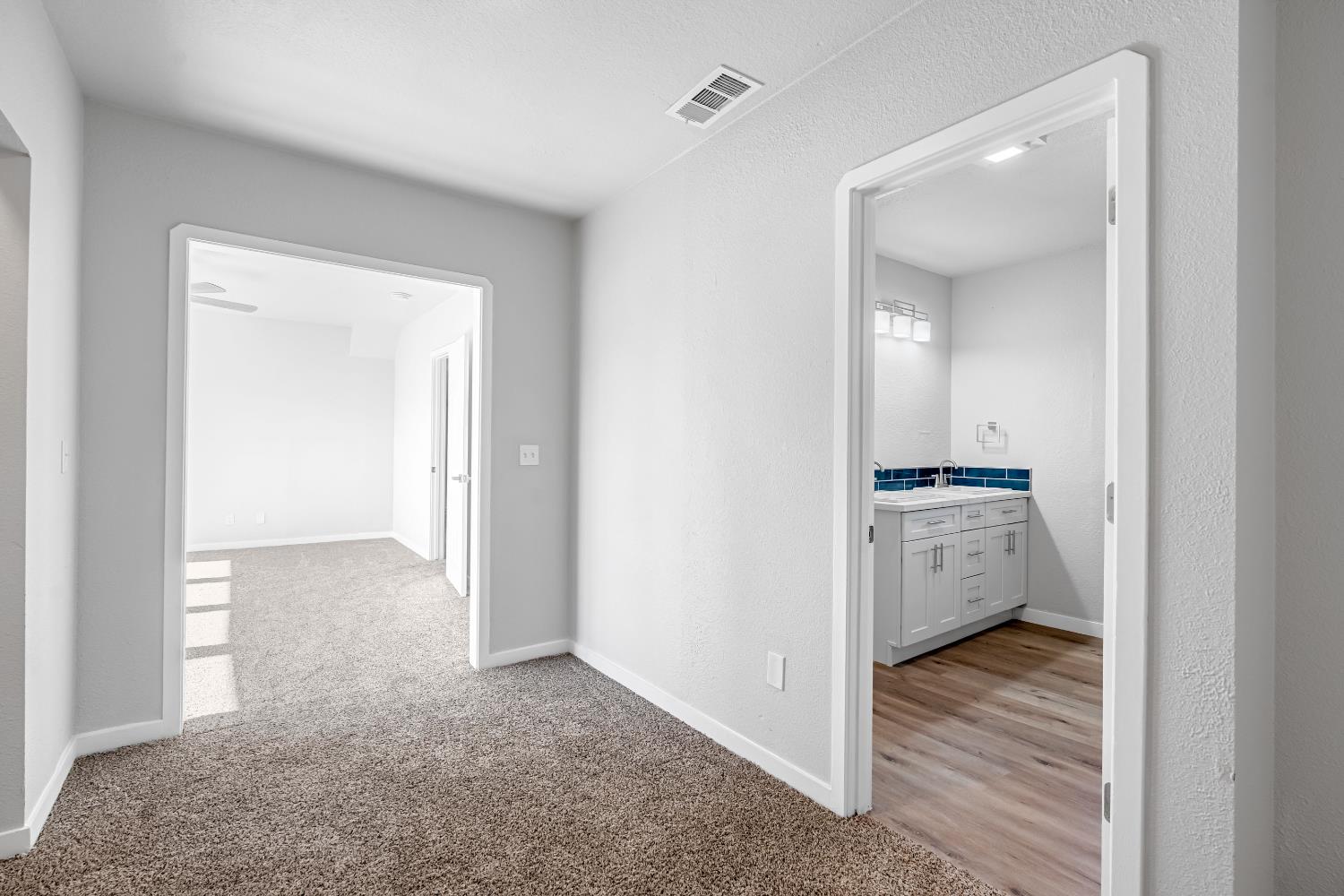 1249 D Street Reedley, CA 93654 - Photo 34 of 40 a view of hallway with kitchen island a sink wooden floor and a living room view