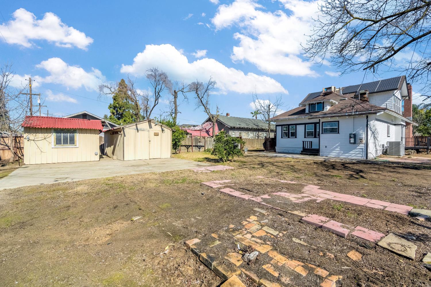 1249 D Street Reedley, CA 93654 - Photo 39 of 40 a view of a white house with a yard and road