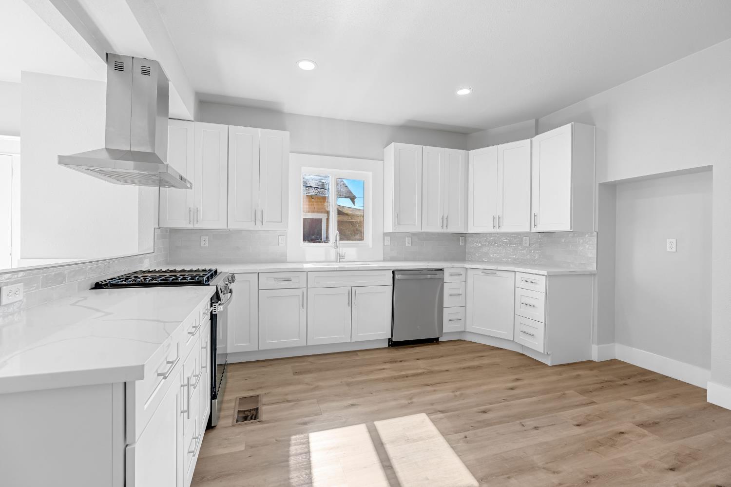 1249 D Street Reedley, CA 93654 - Photo 10 of 40 a kitchen with white cabinets sink and stove