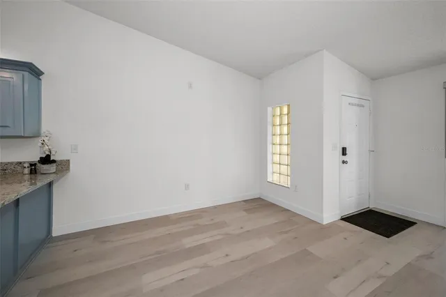 an empty room with windows and cabinet