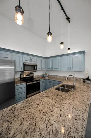 a kitchen with granite countertop stainless steel appliances and wooden cabinets