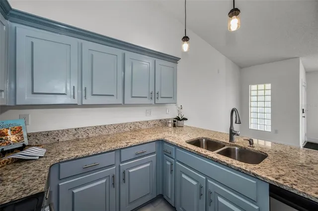 a kitchen with granite countertop a sink a counter top space appliances and cabinets