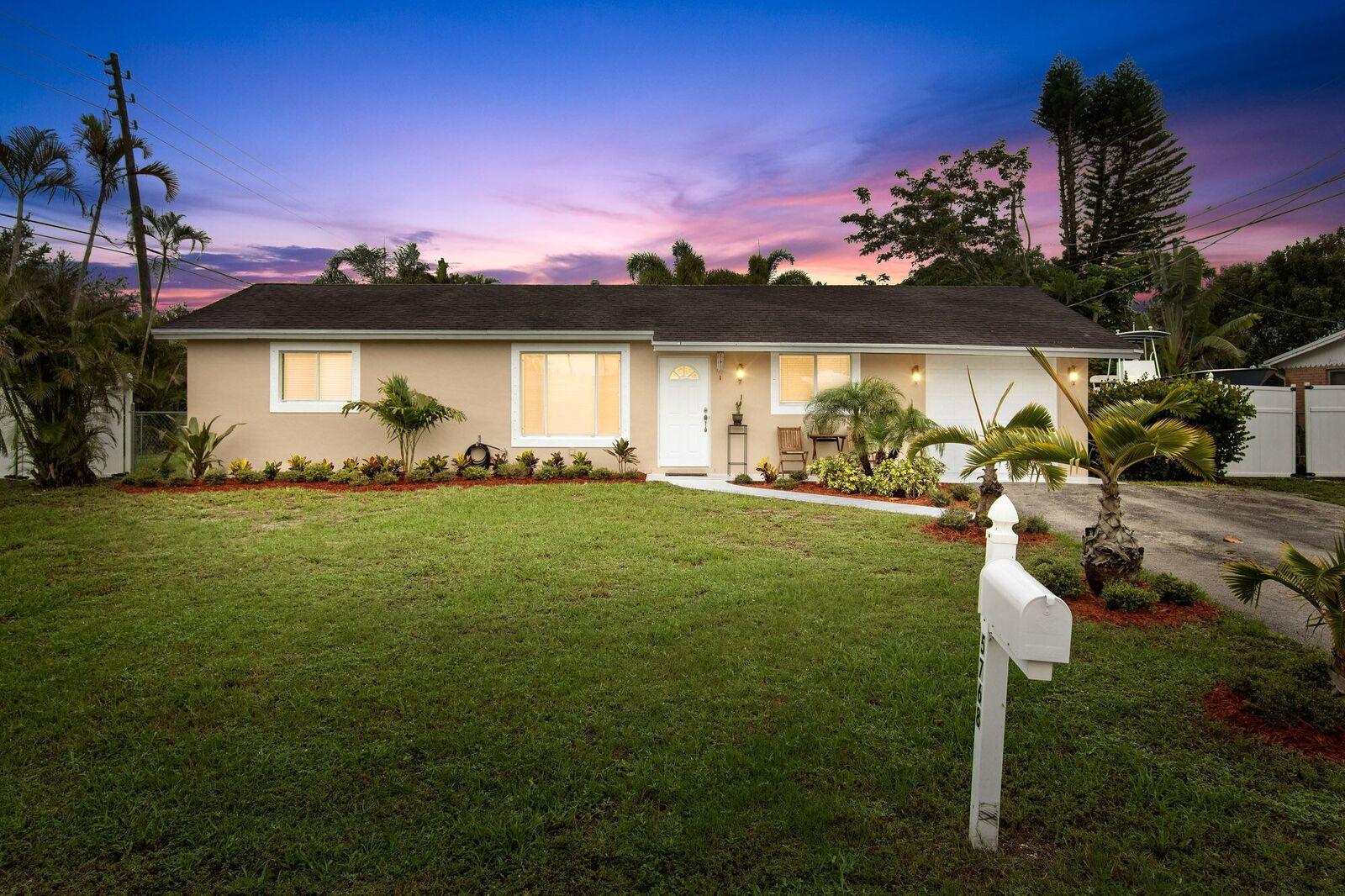 5768 Sullivan Road Jupiter, FL 33458 - Photo 1 of 18 a front view of a house with a yard and lake view
