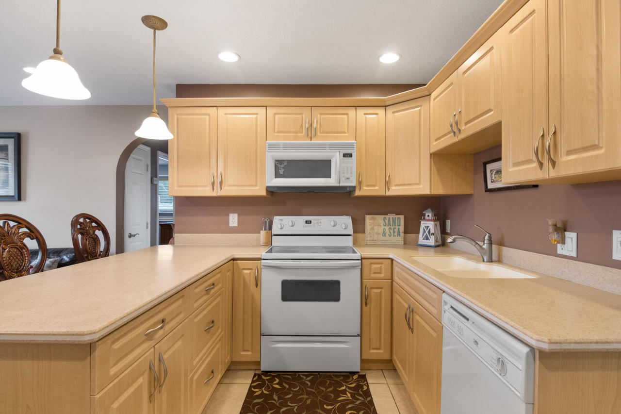 5768 Sullivan Road Jupiter, FL 33458 - Photo 11 of 18 a kitchen with a sink a stove and cabinets