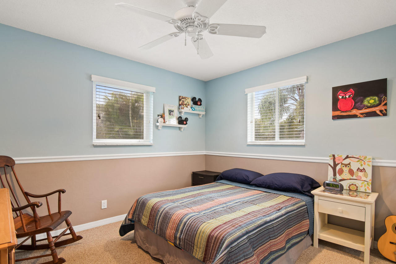 5768 Sullivan Road Jupiter, FL 33458 - Photo 12 of 18 a bedroom with a bed and a chandelier