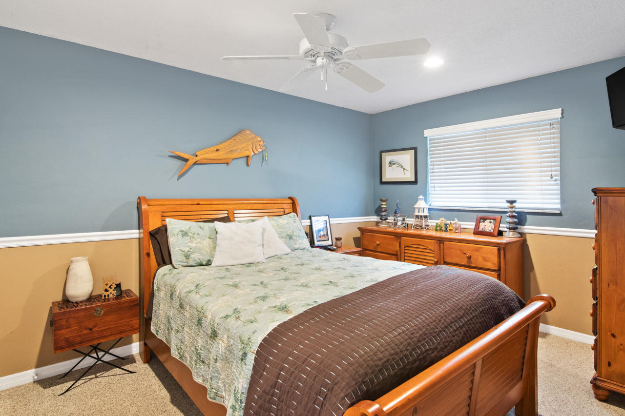 5768 Sullivan Road Jupiter, FL 33458 - Photo 5 of 18 a bedroom with a bed and a chandelier