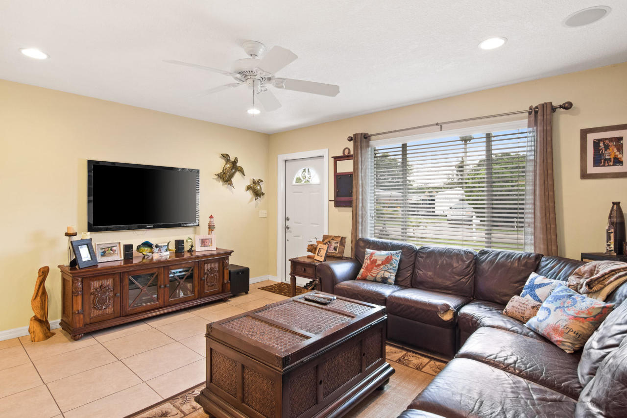 5768 Sullivan Road Jupiter, FL 33458 - Photo 9 of 18 a living room with furniture and a flat screen tv