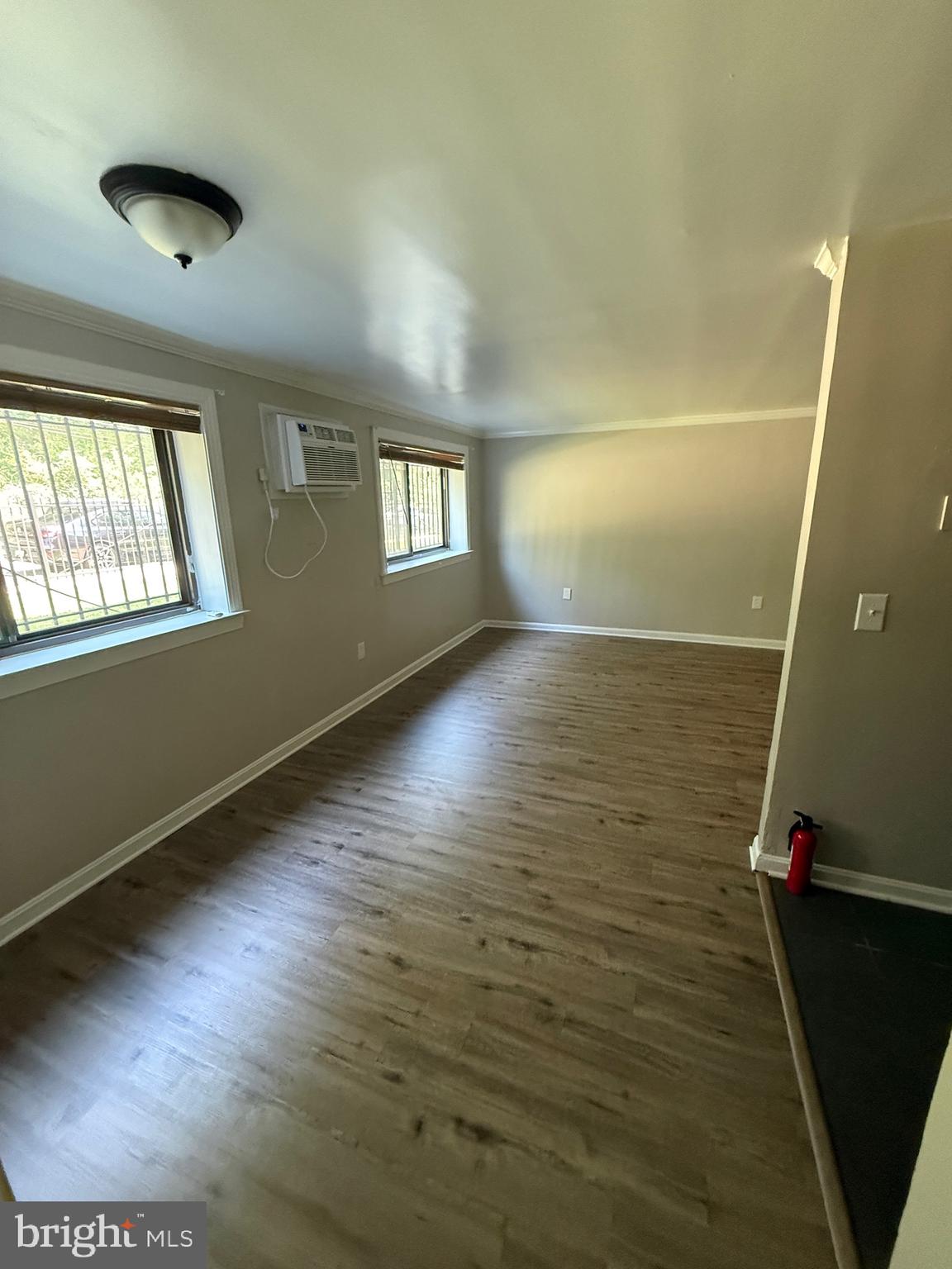 3105 Naylor Road Southeast, Unit 104 Washington, DC 20020 - Photo 2 of 12 a view of an empty room with a window and wooden floor