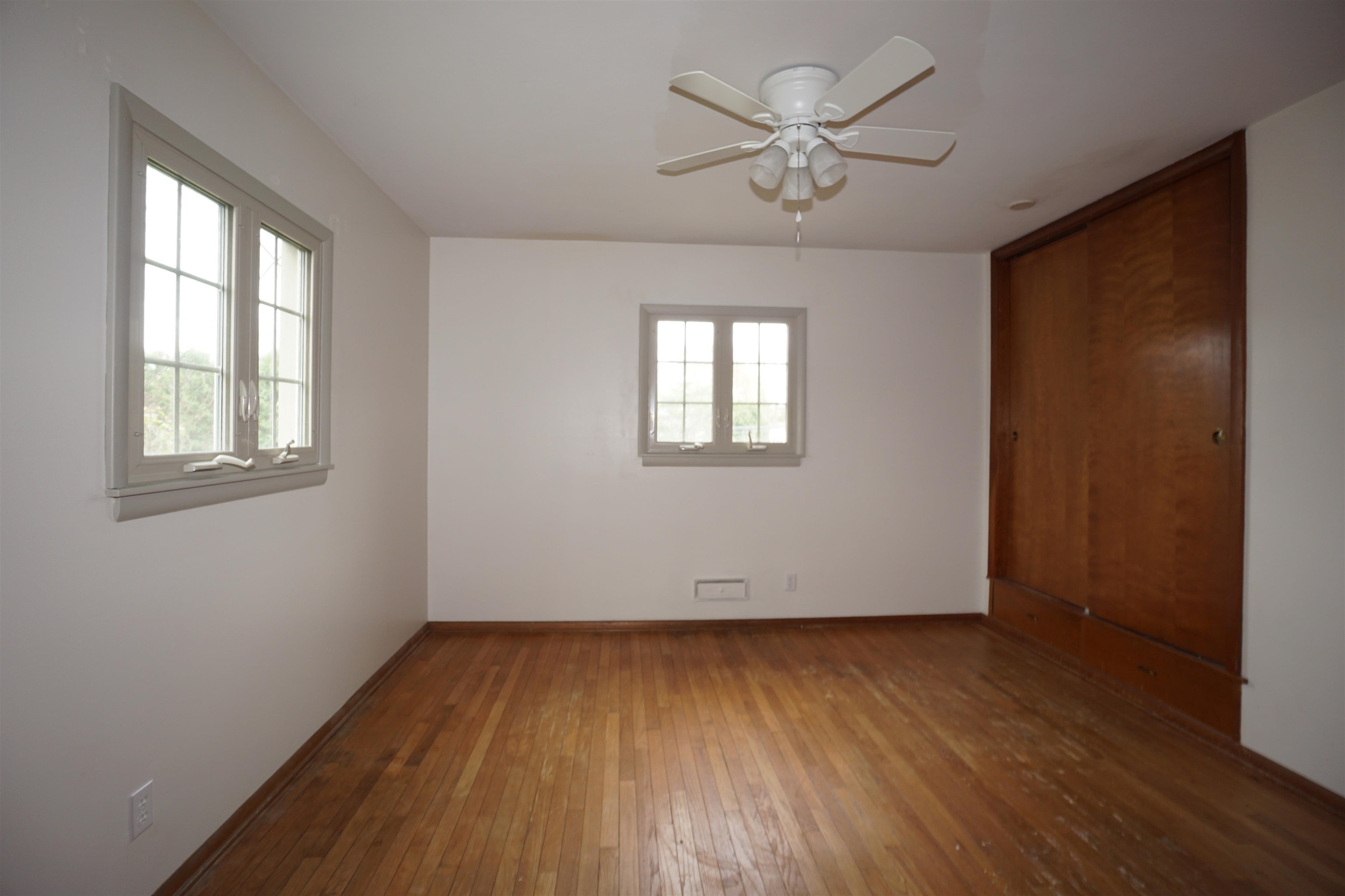 4819 Highcrest Road Rockford, IL 61107 - Photo 21 of 31 an empty room with wooden floor chandelier fan and windows