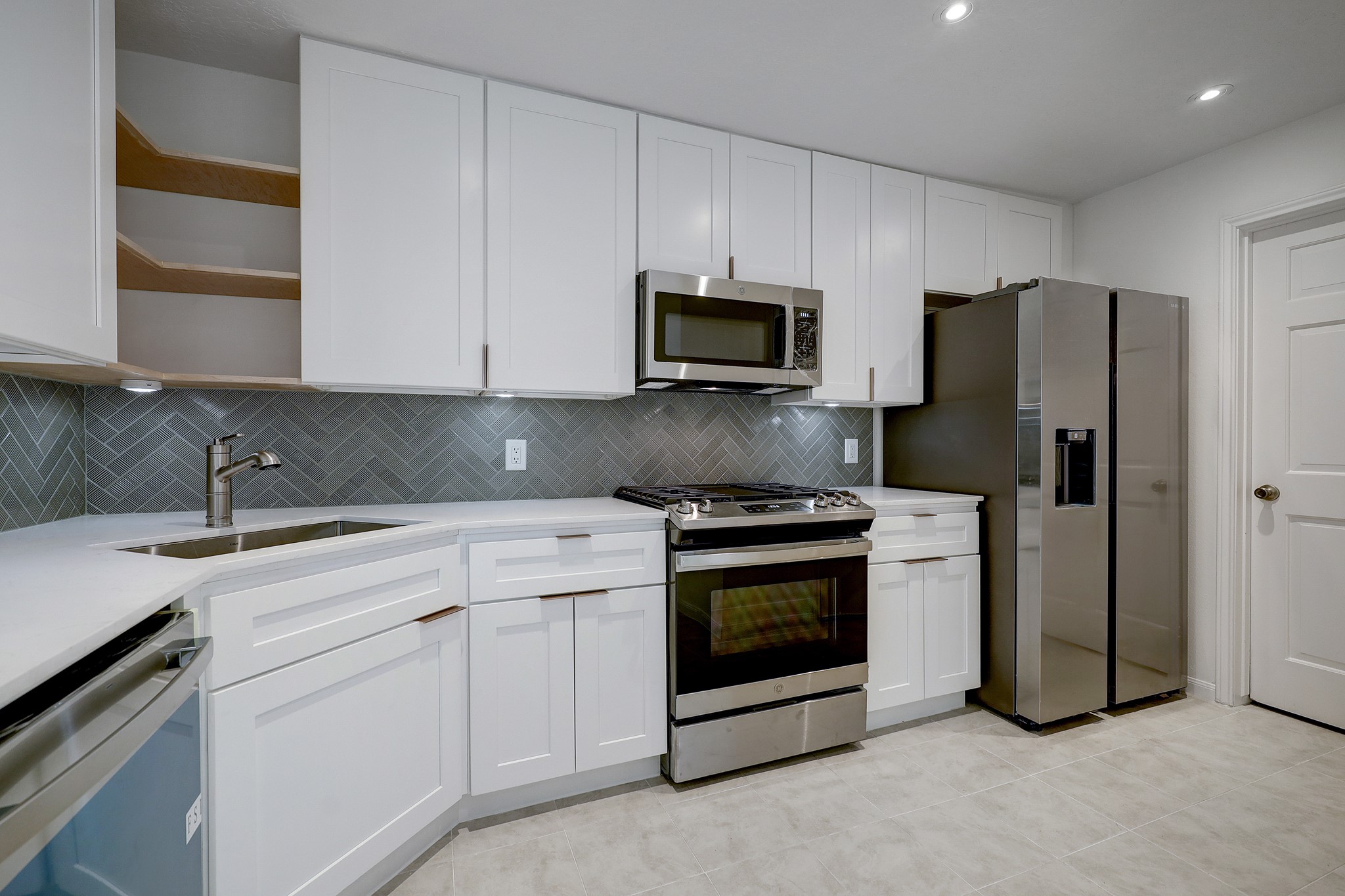 4311 Westheimer Road Houston, TX 77027 - Photo 8 of 23 a kitchen with stainless steel appliances granite countertop white cabinets a sink a stove a refrigerator and white cabinets