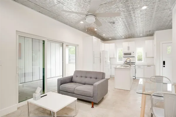 a living room with kitchen island furniture and a chandelier