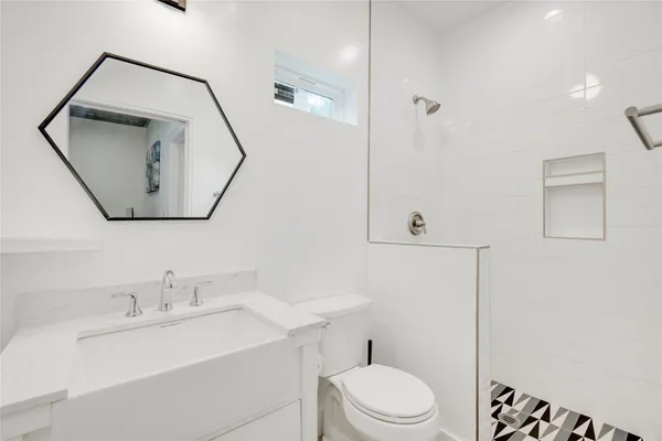 a bathroom with a toilet a sink a mirror and vanity