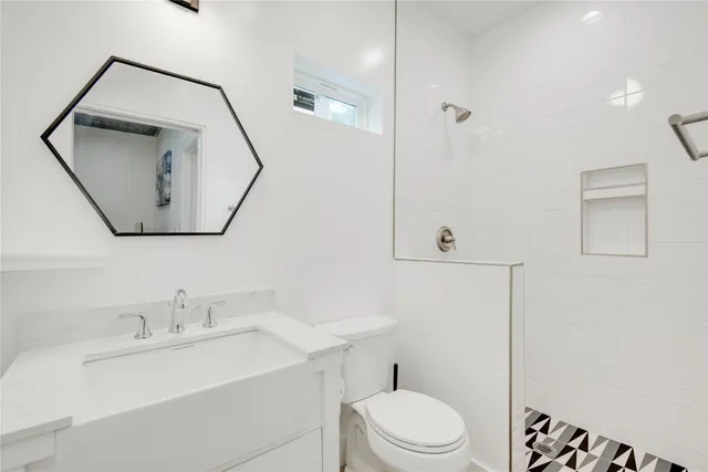 a bathroom with a toilet a sink a vanity and mirror