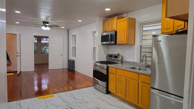 a kitchen with stainless steel appliances granite countertop a refrigerator a stove top oven a sink and dishwasher