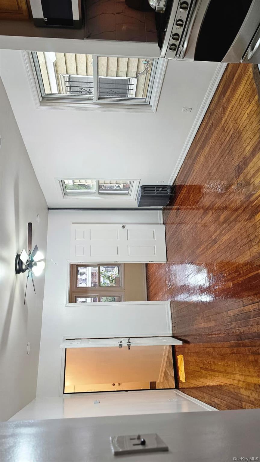 55-23 97th Place Queens, NY 11368 - Photo 2 of 7 a view of an empty room with window and wooden floor