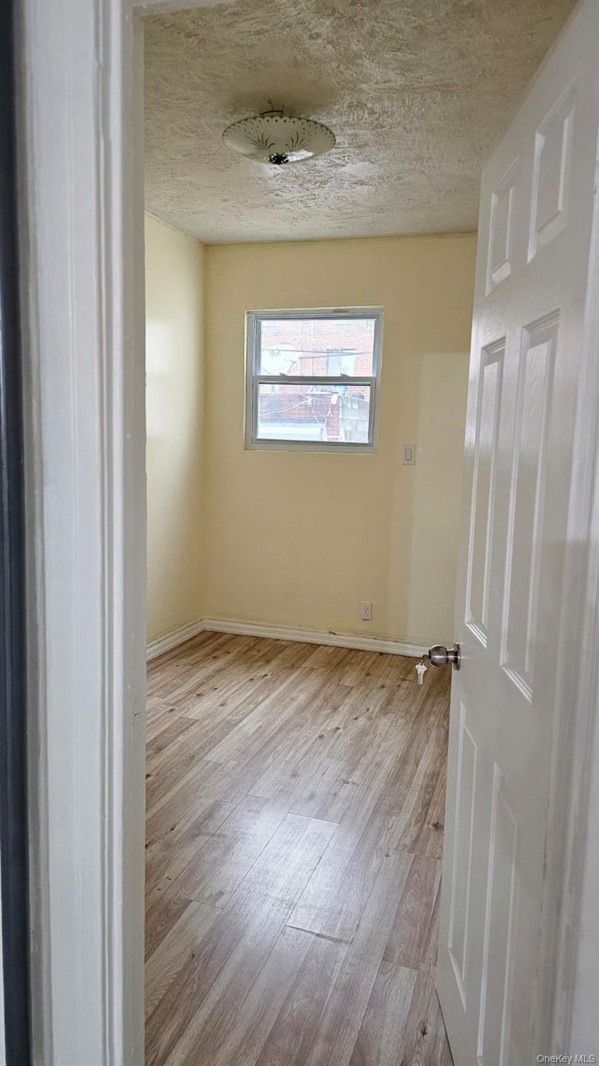 55-23 97th Place Queens, NY 11368 - Photo 5 of 7 a view of an empty room with wooden floor